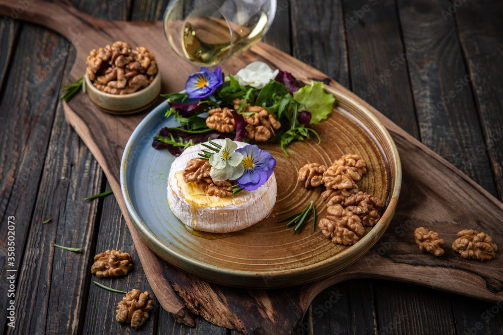 Baked Brie Cheese with Honey, Nuts and White Wine. Beautiful still life for poster or wallpaper for the kitchen