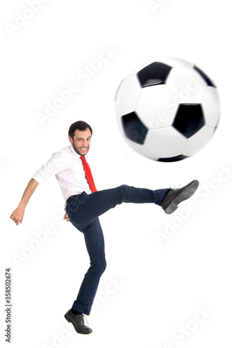 Businessman kicking a football