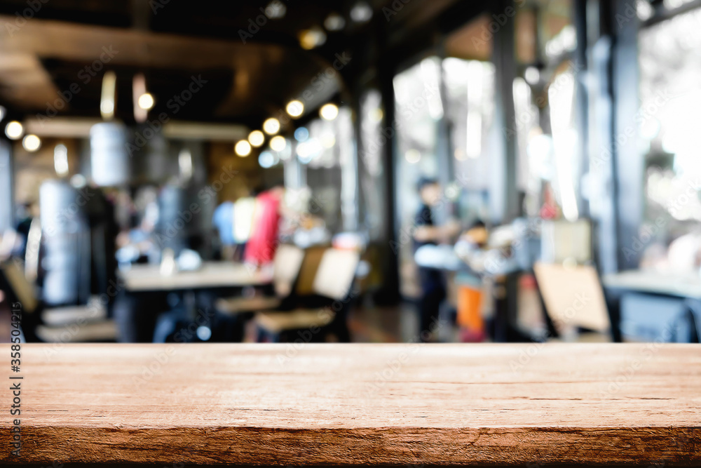 Empty wooden desk space platform over blurred restaurant or coffee shop background for product display montage. Empty wooden desk space platform over blurred restaurant or coffee shop background for product display montage.