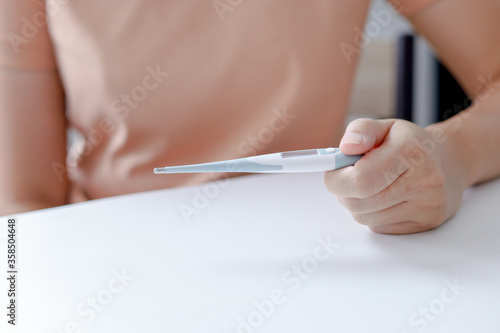 female hand holding a thermometer with high temperature. checking fever in Coronavirus  or Covid-19. patient from the Covid 19 Stay at home.