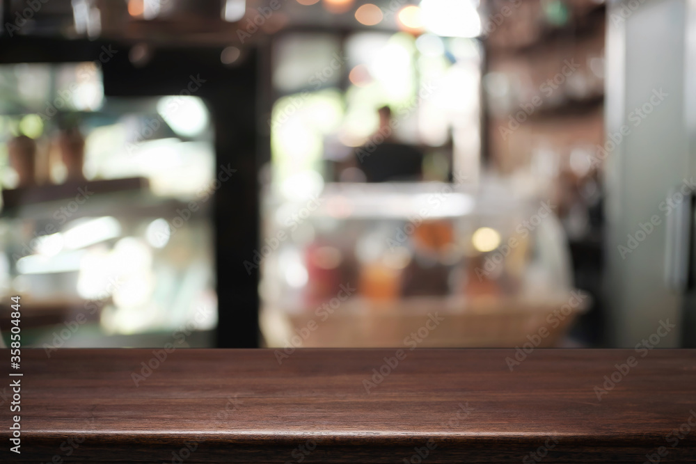 Empty wooden desk space platform over blurred restaurant or coffee shop background for product display montage. Empty wooden desk space platform over blurred restaurant or coffee shop background for product display montage.