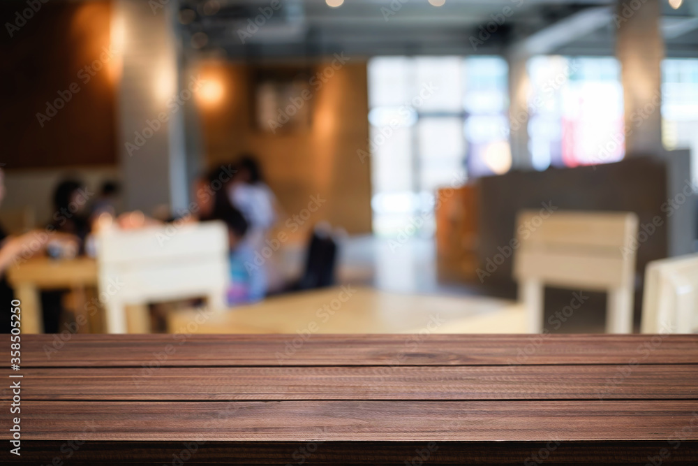 Empty wooden table space platform and blurred restaurant or coffee shop background for product display montage.