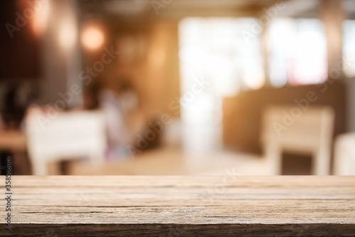 Empty wooden table space platform and blurred resturant or coffee shop background for product display montage. © qOppi