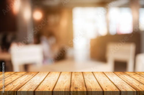 Empty wooden table space platform and blurred resturant or coffee shop background for product display montage.