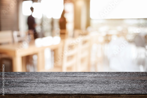 Empty wooden table space platform and blurred restaurant or coffee shop background for product display montage.