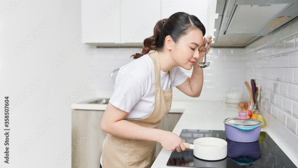 Young woman cooking in the kitchen. Healthy food.