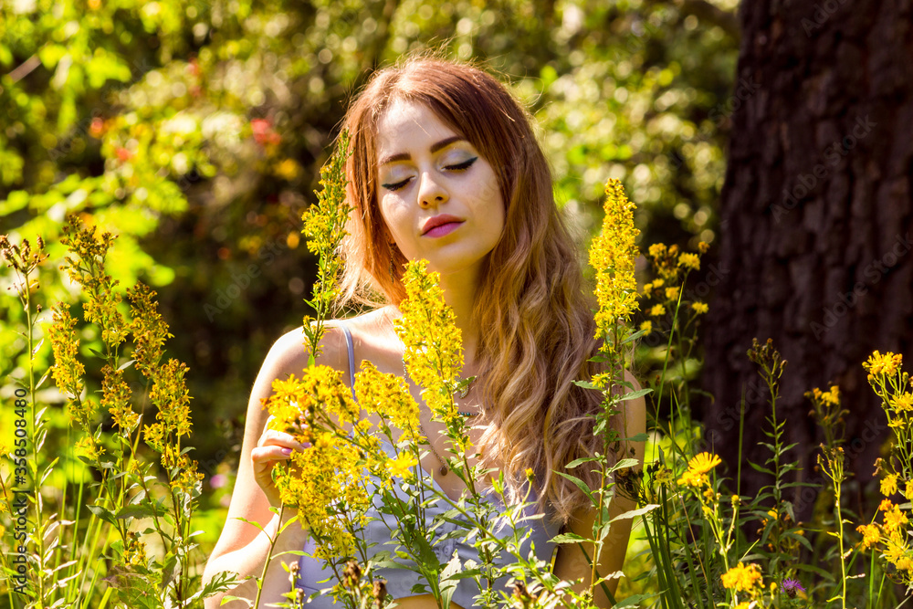 The girl is sitting in the thick grass. The girl is sitting in the thick grass.