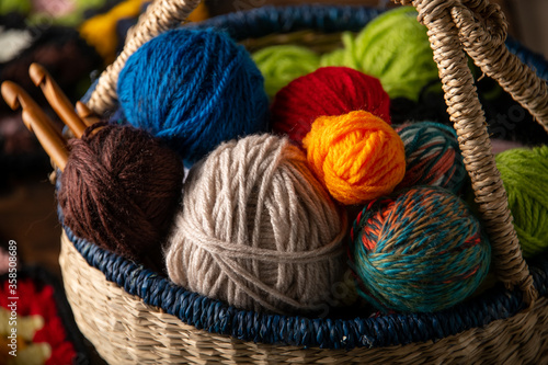 Yarn balls and crochet needles in basket.