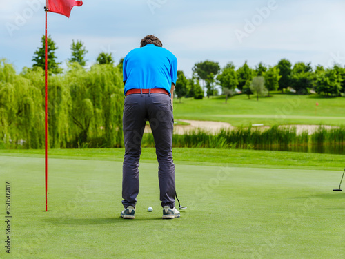 The golfer hits the ball with a putt