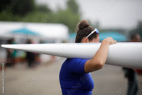Details with the hand of a female professional rower carrying a kayak.