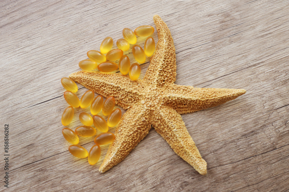 fish oil capsules on a wooden background fish oil capsules on a wooden background