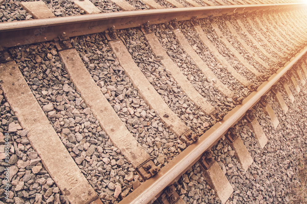 Naklejka premium vintage railway site with old rails and sleepers against bright sunlight