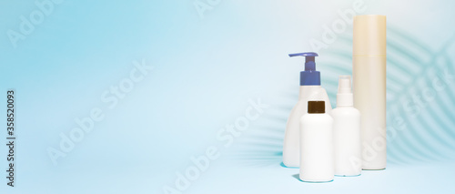 Several containers for spray, liquid soap on clean blue background