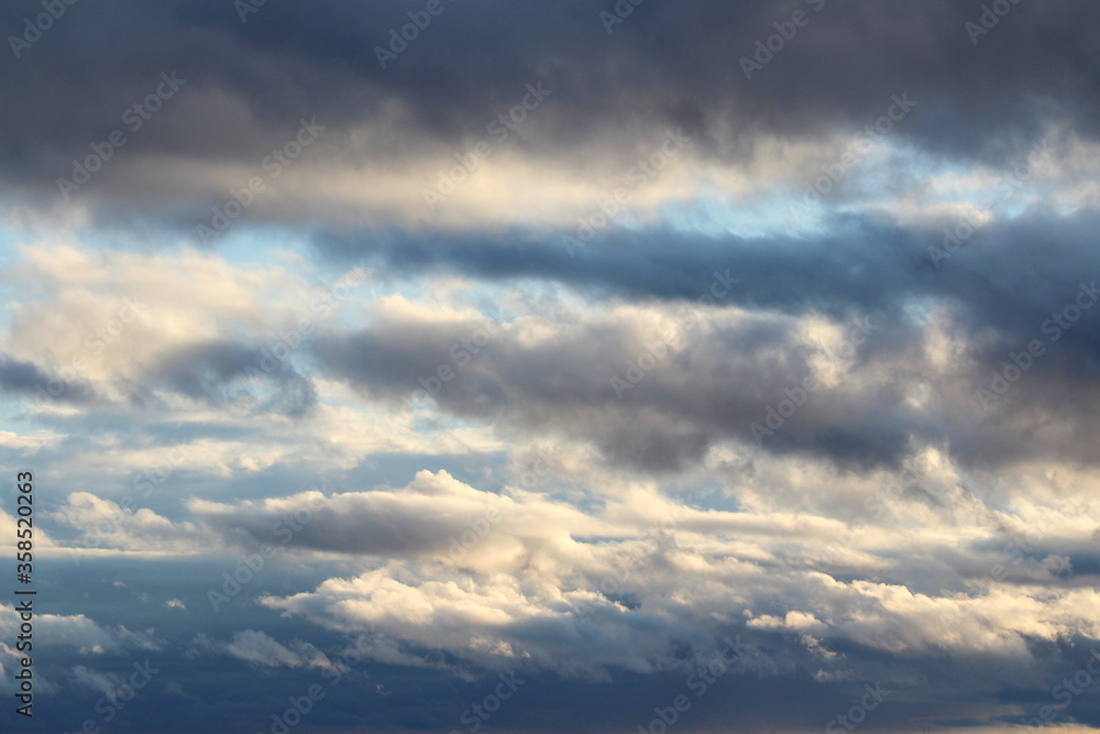 White fluffy clouds on a background of blue sky in summer. The concept of weather and climate