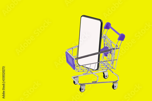 shopping cart with smartphone on yellow background, online shopping concept.