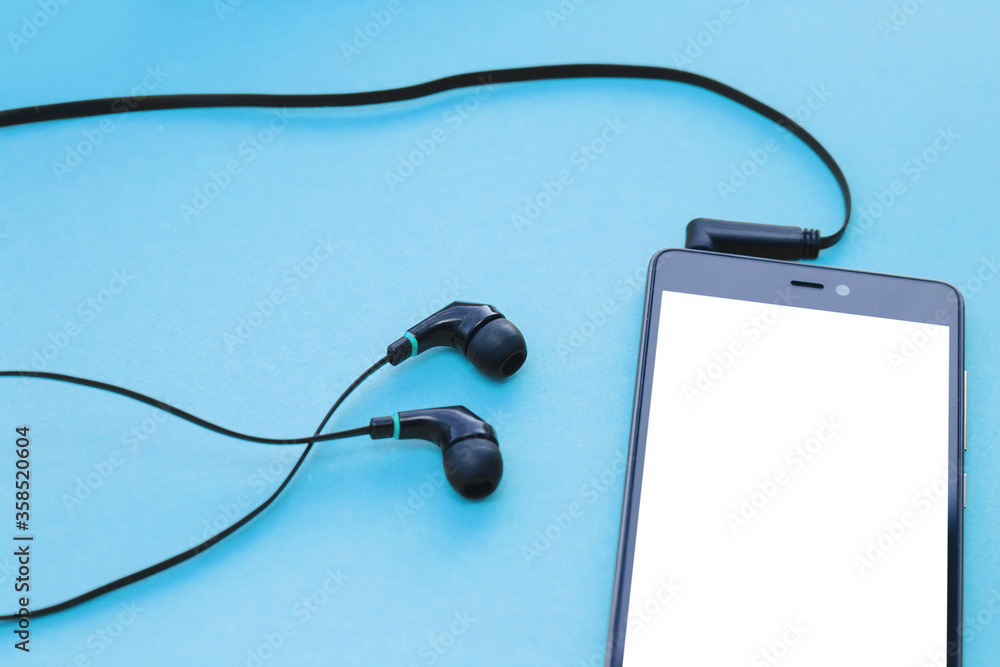 Mockup smartphone and earphones on blue background. Mockup smartphone and earphones on blue background.