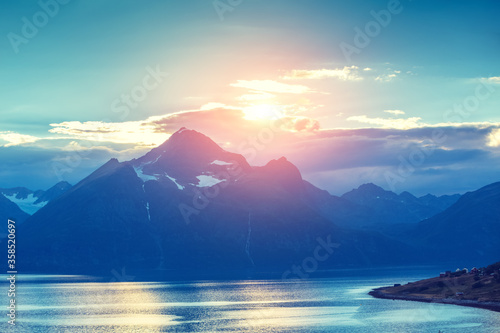 Mountain on the horizon. Rocks in the sea at sunset. Beautiful rocky seascape in the evening. Wilderness, beautiful nature of Norway, Europe