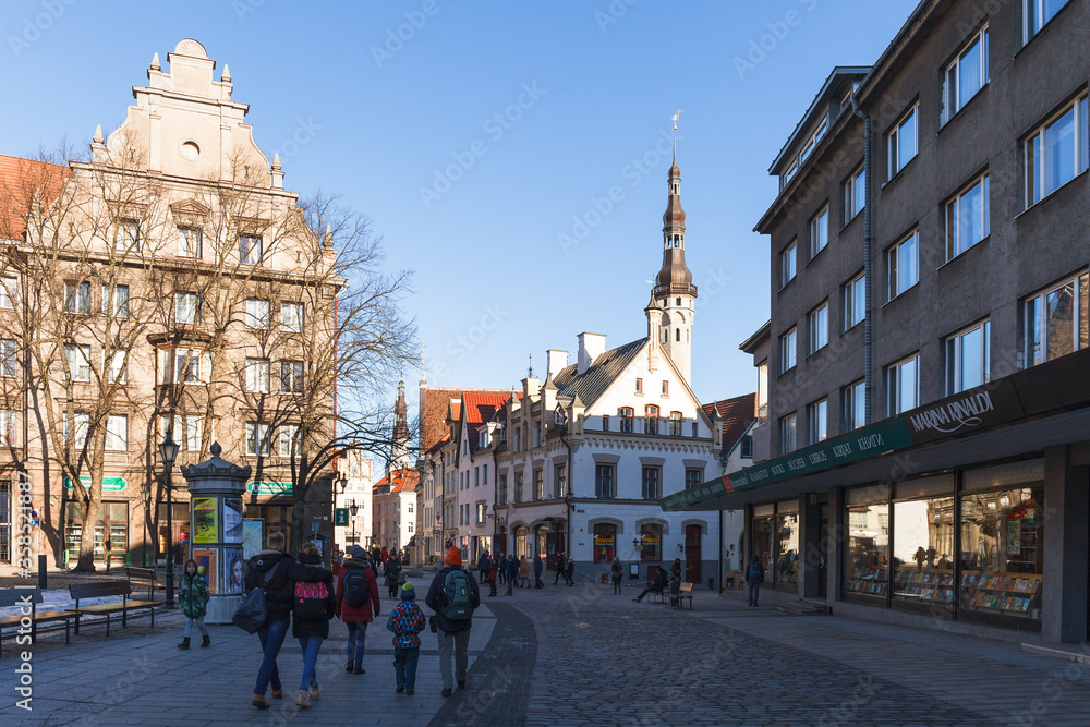 Naklejka premium TALLINN, ESTONIA - DECEMBER 26, 2018: Tourists at street in old town. Sunny day.