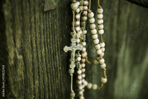 Close up old rosary against ancient wood doors background.