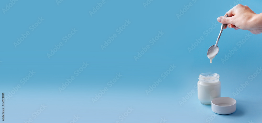 Homemade crockpot greek yogurt in glass jars on light blue background. Homemade crockpot greek yogurt in glass jars on light blue background.