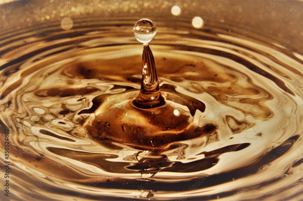 Close up of golden water droplet splashing Close up of golden water droplet splashing