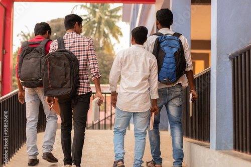 Rear view, group of students going back to college - Friends walking in university college campus - Education, friendship, togetherness, lifetyle concept photo