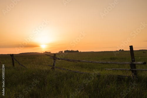 Old fence of logs in a field at sunset. countryside countryside. Plenty of fields.