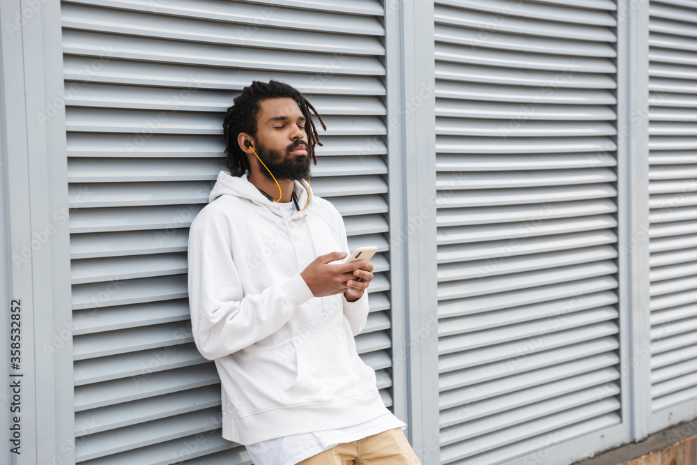 Man with earphones using mobile phone Man with earphones using mobile phone