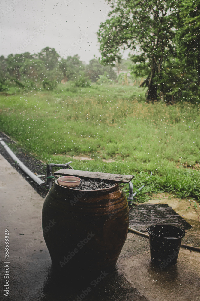 Harvesting rainwater during the rainy season Ripples of rainwater collected in a clay pot - overhead view