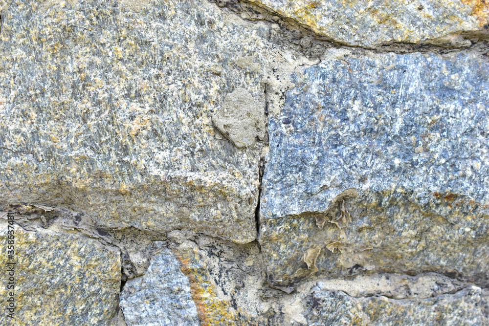 Fototapeta premium Gray blue old wall made of colored stones and cement
