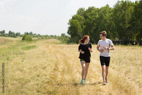 Young family runs in nature. Workout outdoors. Healthy lifestyle concept.