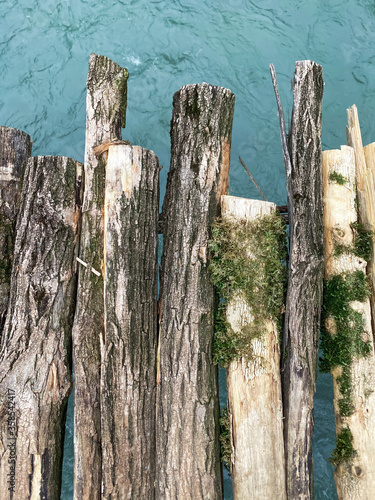 Old bridge over the river closeup. Textured boards with moss and cracks. Mountain river.
