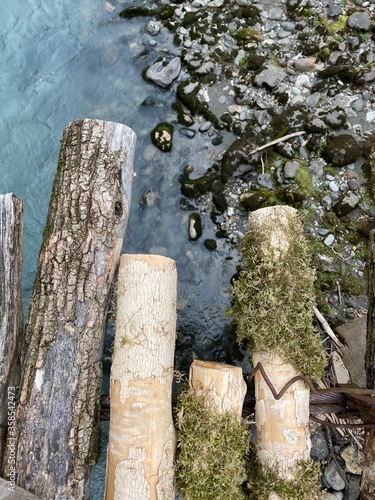 Old bridge over the river closeup. Textured boards with moss and cracks. Mountain river.