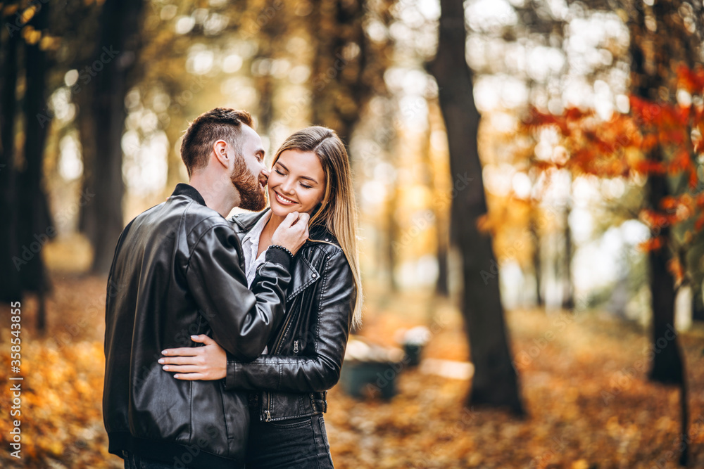 Man and woman hugging and smiling in the background of autumn park. Man and woman hugging and smiling in the background of autumn park.