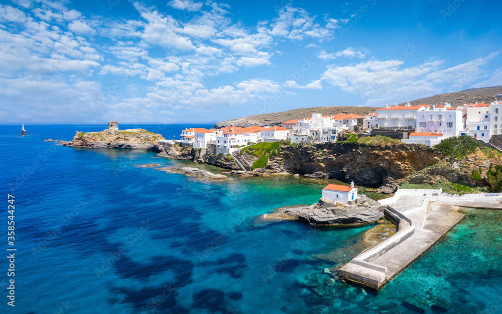 Panoramic view to the beautiful town of Andros island with white houses and red roofs over turquoise sea, Cyclades, Greece