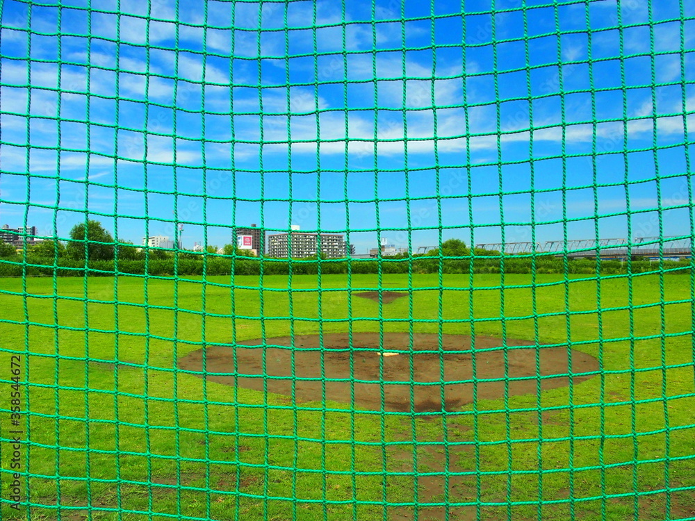 Obraz premium バックネット越しに見る初夏の平日の江戸川河川敷風景