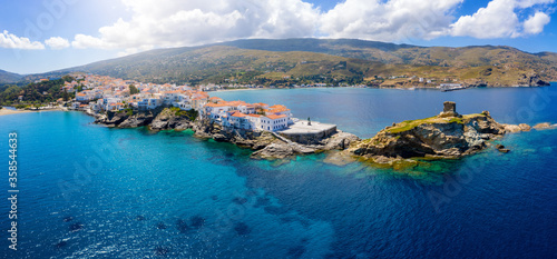 Fototapeta Naklejka Na Ścianę i Meble -  Panoramic aerial view to the town of Andros island, situated on rocks above the turquoise sea, Cyclades, Greece