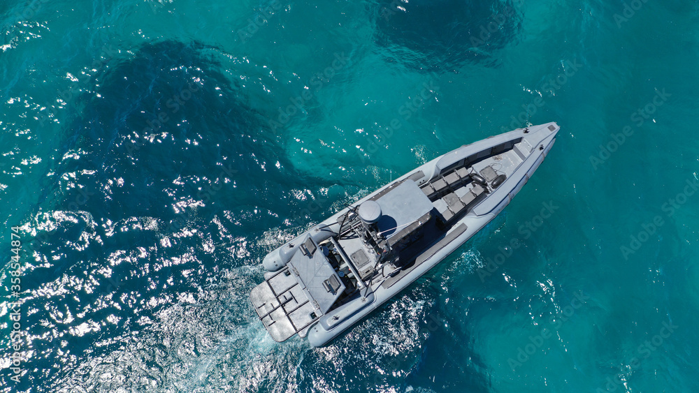 Naklejka premium Aerial drone photo of luxury inflatable speed boat cruising in deep blue Aegean sea, Mykonos island, Cyclades, Greece