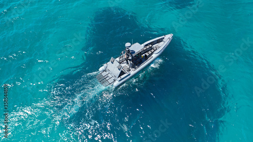 Aerial drone photo of luxury inflatable speed boat cruising in deep blue Aegean sea, Mykonos island, Cyclades, Greece