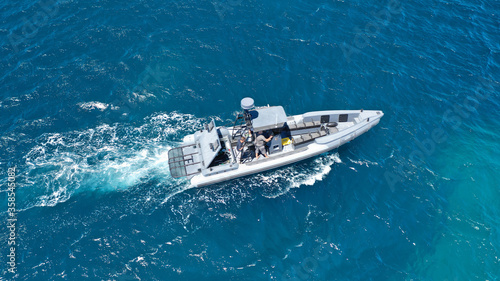 Aerial drone photo of luxury inflatable speed boat cruising in deep blue Aegean sea, Mykonos island, Cyclades, Greece