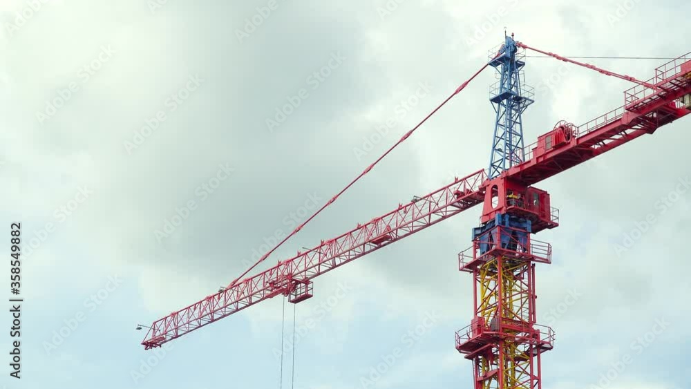 Big industrial tower crane with blue sky on background. Concrete plates weight balance. High building construction site Big industrial tower crane with blue sky on background. Concrete plates weight balance. High building construction site