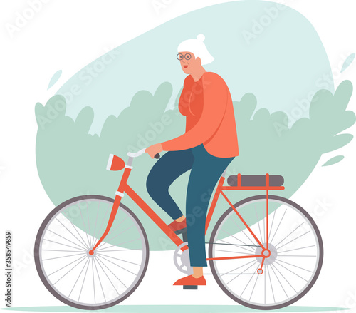 Elderly woman riding a bike in the park. Active retirement concept.