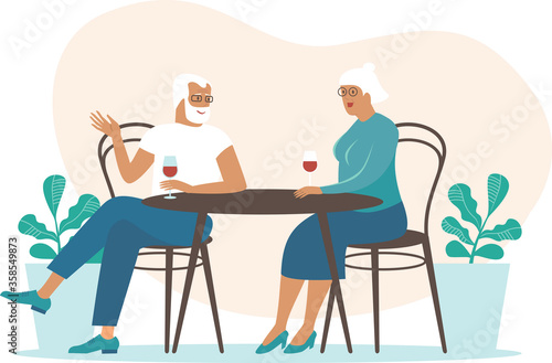 Senior couple spending time on the cafe summer terrace talking and drinking wine.