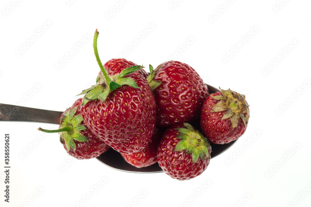 A spoon full of strawberries on a white background A spoon full of strawberries on a white background