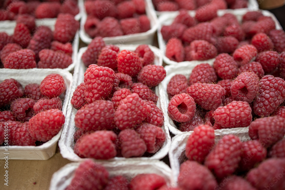 raspberries in containers on a stall forming a background raspberries in containers on a stall forming a background