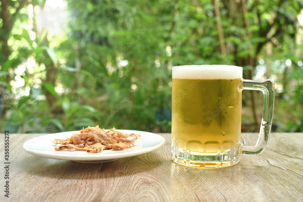 baked dry salty squid slice on plate eat couple with cold beer on table baked dry salty squid slice on plate eat couple with cold beer on table