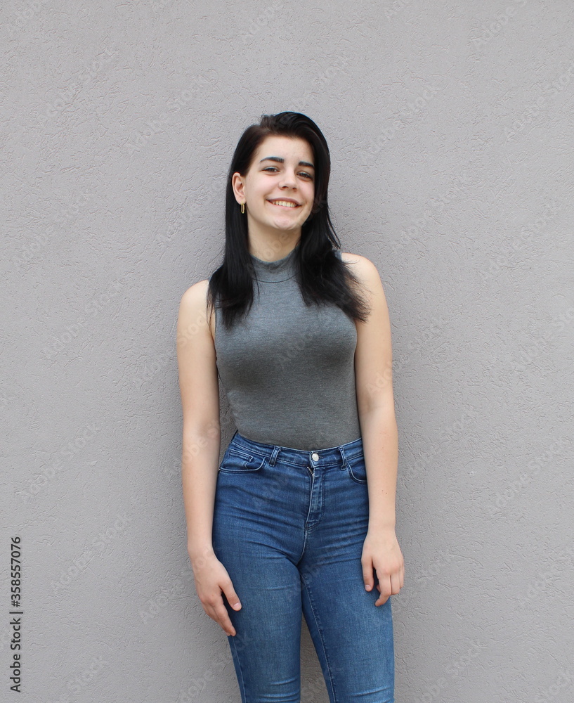 Portrait of a young black-haired girl in front of a gray background Portrait of a young black-haired girl in front of a gray background