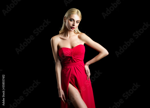 Vogue fashion style of young girl. High Fashion model woman posing in studio. Red derss.