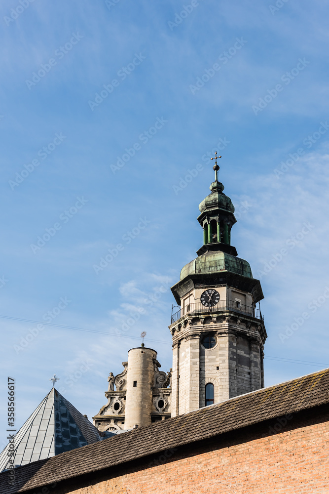 korniakt tower and monastery wall against blue sky in lviv, ukraine