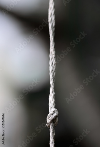 The knot of the old rope twine in the gray background